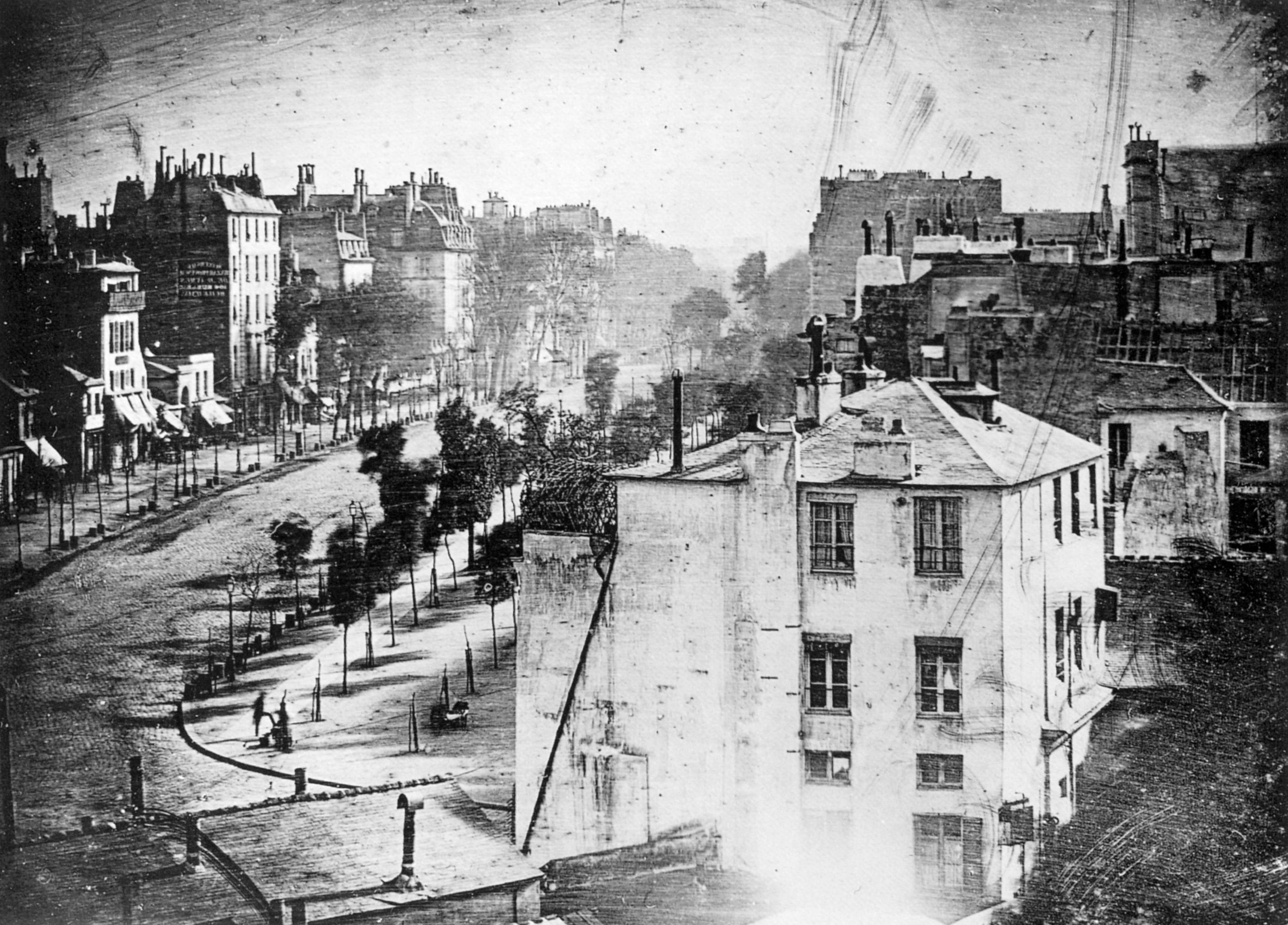 Louis Daguerre, Boulevard du Temple u Parizu 1838., rana dagerotipija s dvjema ljudskim figurama pri dnu prizora.